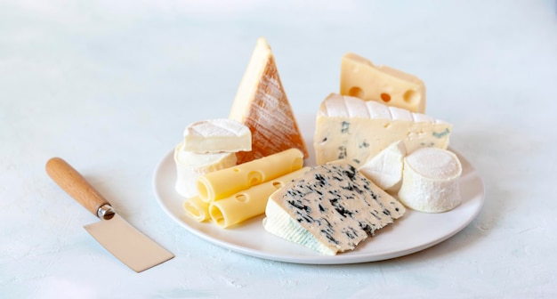 Piatto di formaggi con diversi tipi di formaggio francese su sfondo bianco