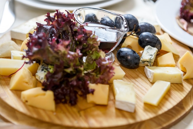 Piatto di formaggi con olio d'oliva e uva nel ristorante da vicino. Concetto di cibo