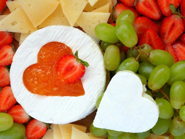 Piatto di formaggi con uva e fragole