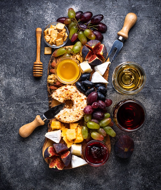 Piatto di formaggi con uva e vino