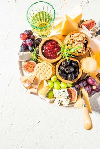 Piatto di formaggi o tagliere di formaggi con frutta, erbe aromatiche, miele e cracker