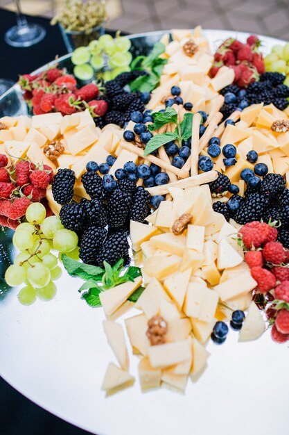 Piatto di formaggi servito con marmellata di uva cracker di fichi e noci