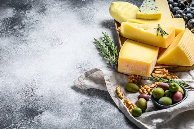 Piatto di formaggi servito con uva, cracker, olive e noci.