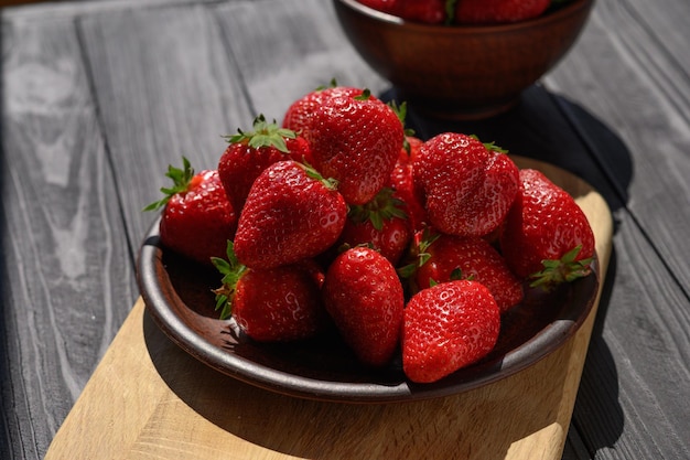 Piatto di fragole succose rosse su un tavolo di legno rustico Il concetto di spuntini sani e dietetici