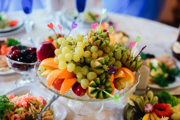 Piatto di frutta con arancia fresca, uva, kiwi e mela