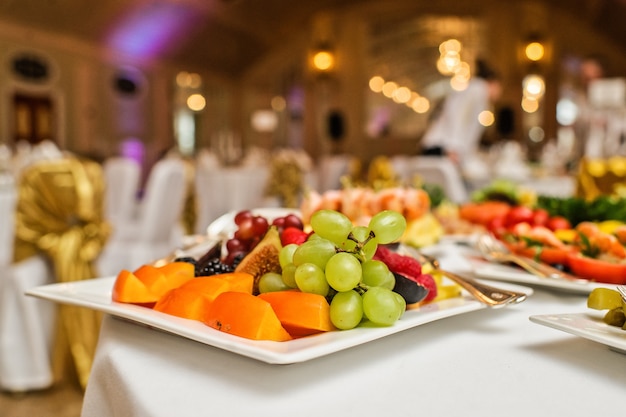 Piatto di frutta con uva, pesca, fichi e cachi, cena al ristorante