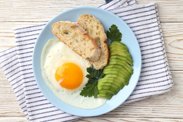 Piatto di gustosa colazione su fondo di legno bianco