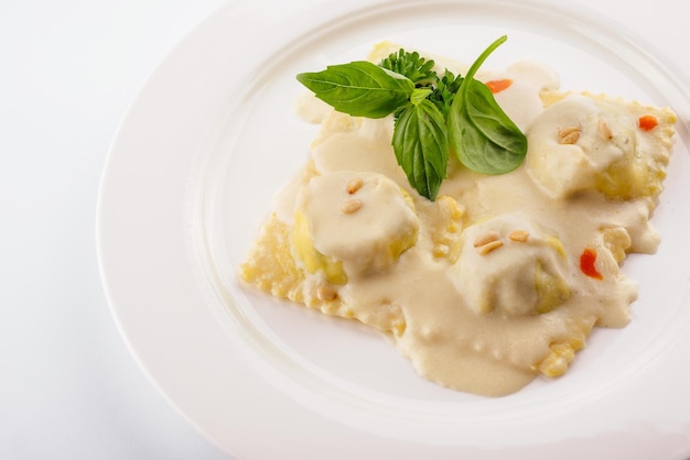 Piatto di gustosi ravioli tradizionali italiani con basilico