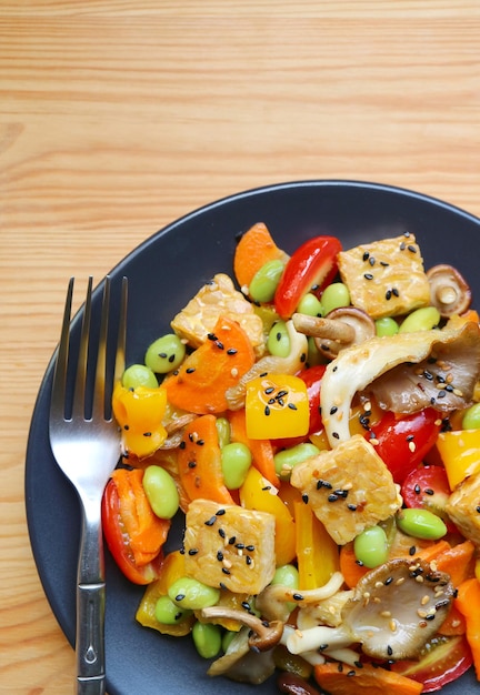 Piatto di insalata di verdure colorate con cubetti di tempeh arrostiti e funghi ostrica