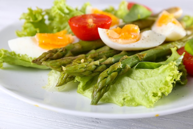 Piatto di insalata dietetica con asparagi bolliti e primo piano dell'uovo