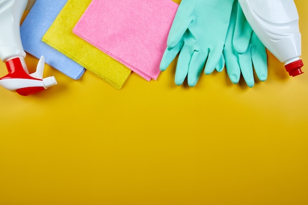 Piatto di laici varietà di prodotti per la pulizia della casa sul tavolo giallo