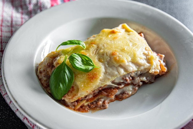 piatto di lasagne salsa besciamella carne macinata formaggio grattugiato pasto cibo spuntino sul tavolo copia spazio