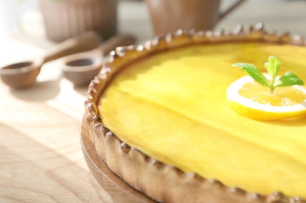 Piatto di legno con gustosa torta di cagliata di limone sul primo piano della tavola