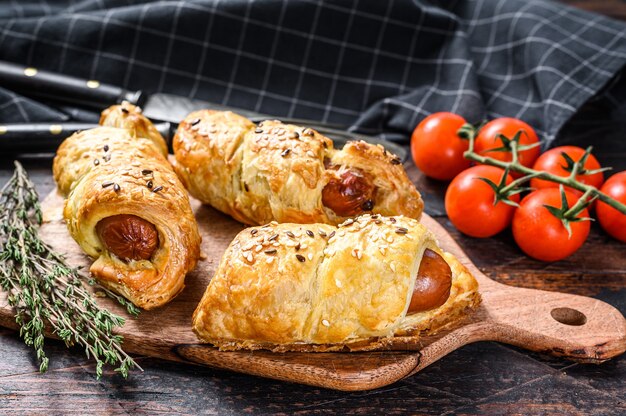 Piatto di legno con rotoli di salsiccia nell'impasto