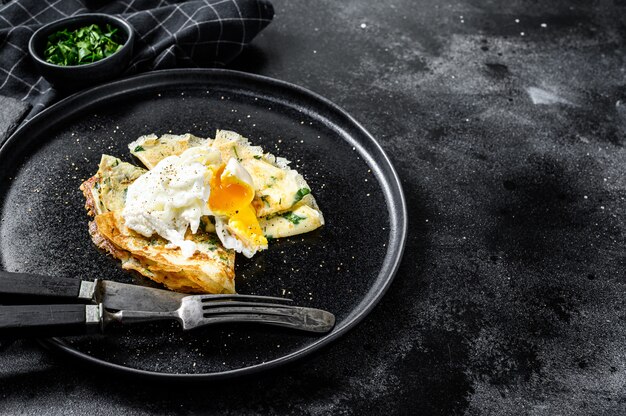 Piatto di pancake ripieni di spinaci e uova. Sfondo nero.