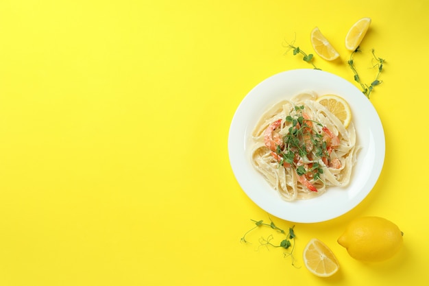 Piatto di pasta saporita di gamberetti su giallo