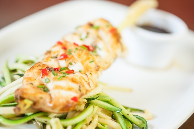 Piatto di pesce asiatico con tagliatelle e verdure alla julienne