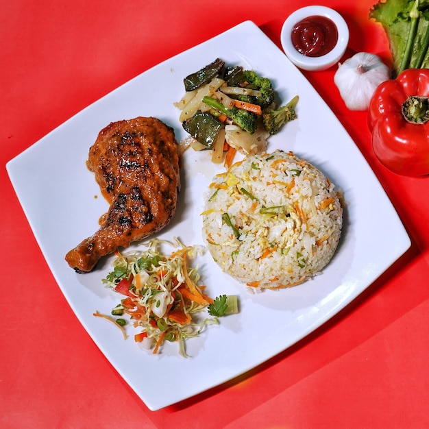 Piatto di pollo Peri Peri con insalata di riso fritto e salsa servita nella vista dall'alto del piatto del fastfood