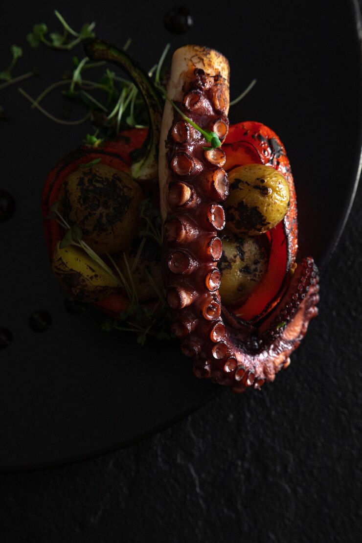 Piatto di polpo alla griglia con delicatezza di mare su sfondo scuro