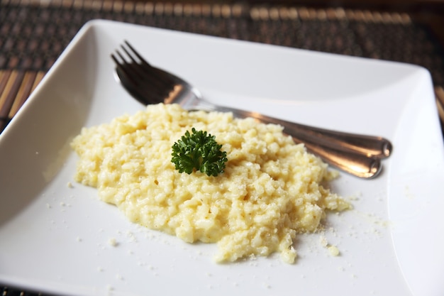 Piatto di risotto alle erbe su fondo di legno