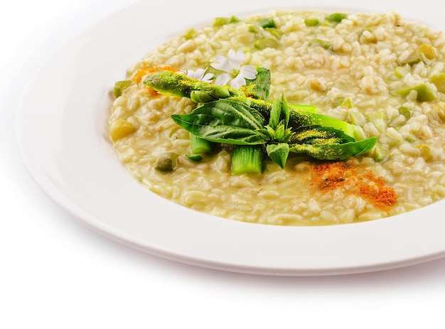 Piatto di risotto con asparagi isolato su piano bianco