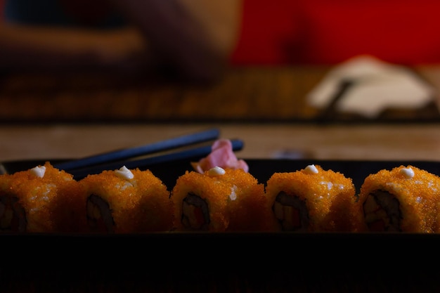 Piatto di rotolo di sushi California con tobiko all'arancia e zenzero. Cibo tradizionale giapponese