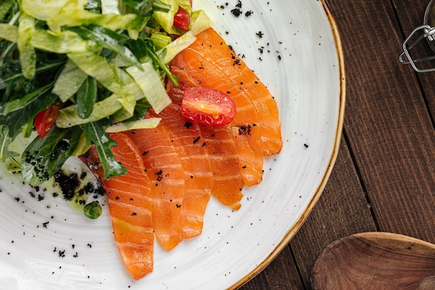 Piatto di salmone affettato salato e insalata verde