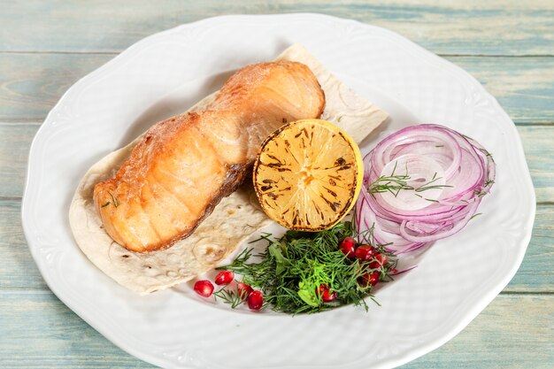 Piatto di salmone grigliato con melograno e limone