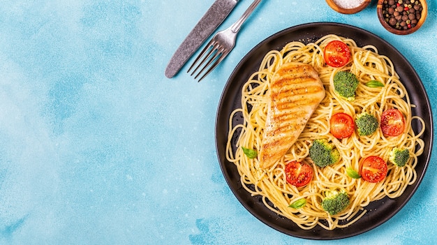 Piatto di spaghetti con pomodoro, broccoli e pollo