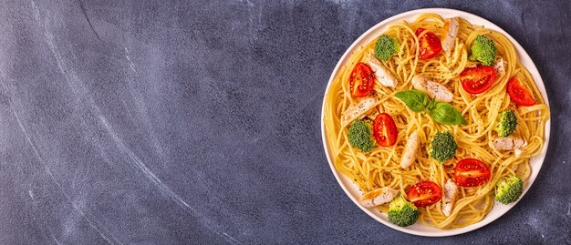 Piatto di spaghetti con pomodoro, broccoli e pollo