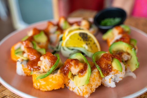 Piatto di sushi californiano con avocado, gamberi e salsa piccante. Concetto di ristorante di cibo gourmet