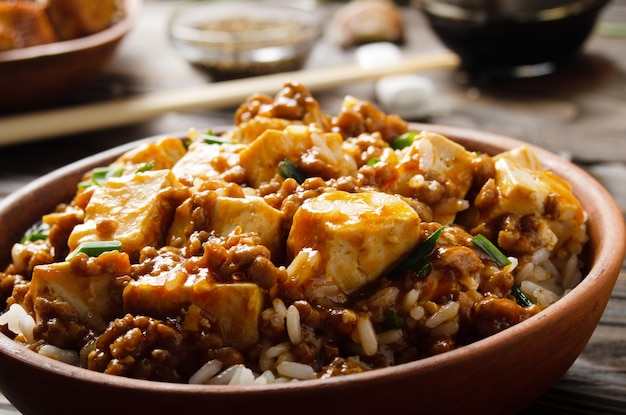 Piatto di tofu mapo di cibo tradizionale cinese autentico con erba cipollina di maiale riso al vapore salsa di soia e spezie closeup