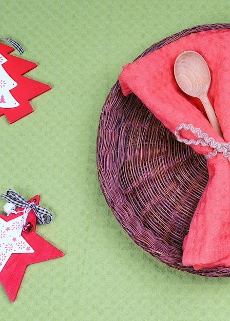 Piatto di vimini vuoto e cucchiaio di legno con decorazioni di Natale e Capodanno per il menu delle vacanze.