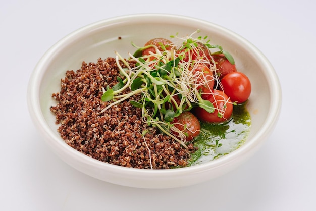 Piatto dietetico con salsa di spinaci e pomodorini quinoa e microgreen