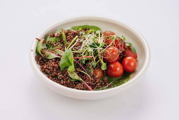 Piatto dietetico con salsa di spinaci e pomodorini quinoa e microgreen