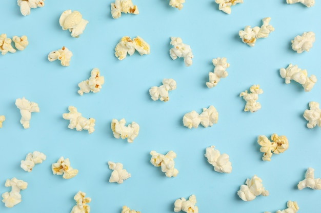 Piatto disteso con popcorn su spazio blu. Cibo per il cinema