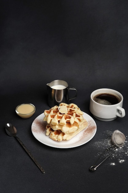 Piatto fatto in casa di gustosi waffle su uno sfondo di cemento nero