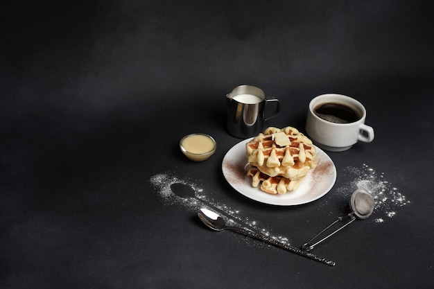 Piatto fatto in casa di gustosi waffle su uno sfondo di cemento nero