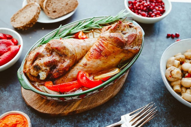 Piatto festivo per le gambe di tacchino arrosto del Ringraziamento con verdure su un tavolo con spuntini