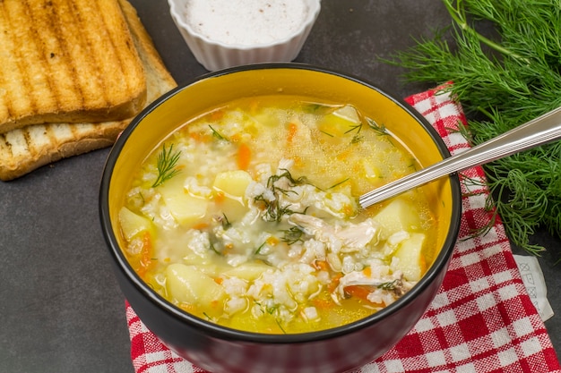 Piatto fondo di zuppa di riso al pollo sul tavolo