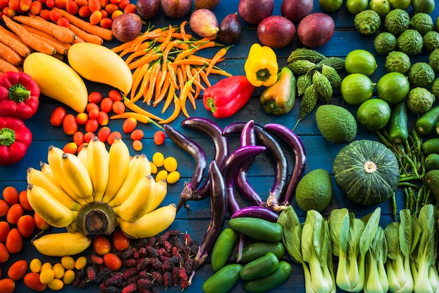 Piatto giacente di frutta fresca e verdure per lo sfondo, diversi frutti e verdure per mangiare sano, frutta e verdura colorati su sfondo blu plancia