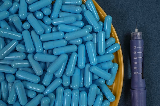 Piatto giallo pieno di capsule medicinali blu che rappresentano l'overdose di droga