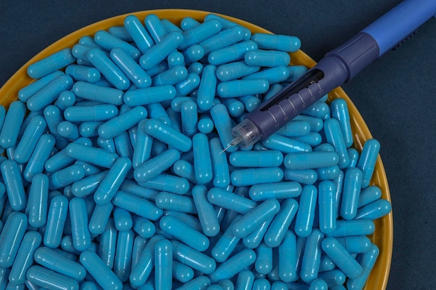 Piatto giallo pieno di capsule medicinali blu che rappresentano l'overdose di droga