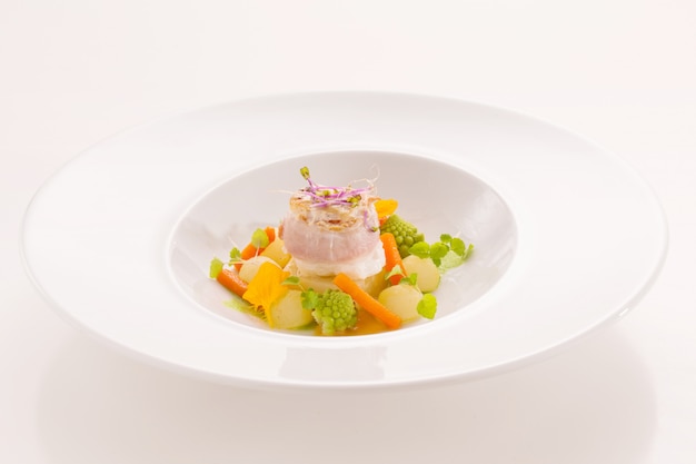 Piatto gourmet a base di pesce, con piccole verdure