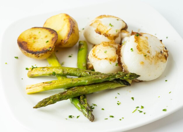 Piatto gourmet di seppie con patate arrosto e asparagi