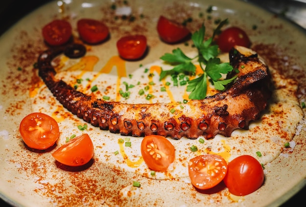 Piatto gourmet di tentacolo di polpo alla griglia in un ristorante elegante.