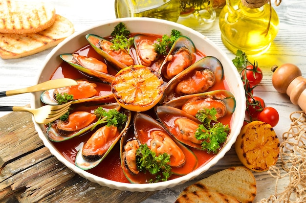 Piatto grande con cozze cotte in salsa di pomodoro con aglio prezzemolo e limone Spazio libero per il testo