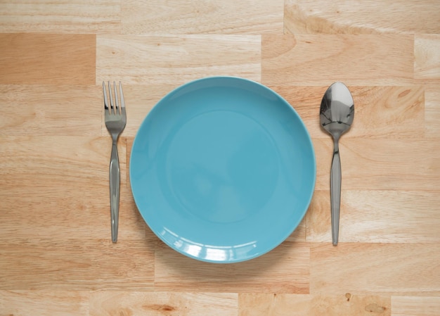 piatto in ceramica con fondo in legno cucchiaio e forchetta