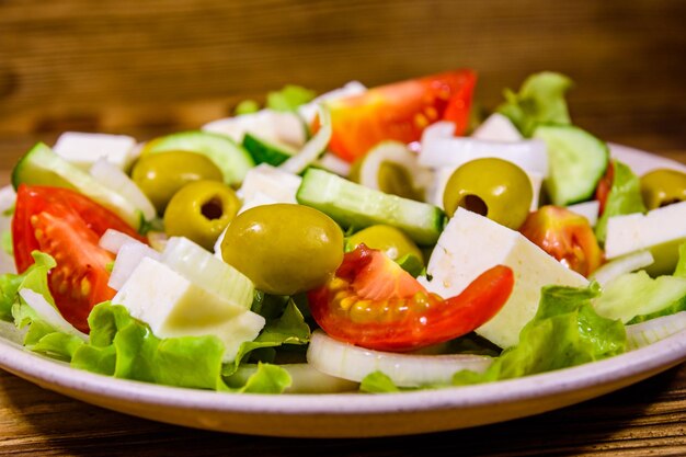 Piatto in ceramica con insalata greca su tavola di legno