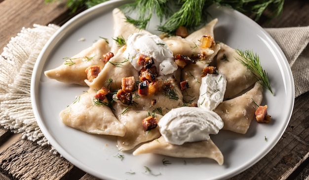 Piatto pierogi tradizionale polacco, ucraino o slovacco con panna acida, pancetta e aneto.